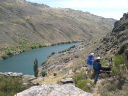 A person walking along a track high above the turquoise waters of the Roxburgh Gorge.