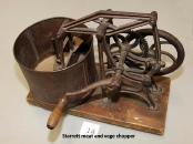 A hand-cranked Starrett meat and vegetable chopper mounted on a wooden board.