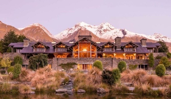 Blanket Bay Lodge at dusk below the snow-covered Humboldt Mountains, Glenorchy