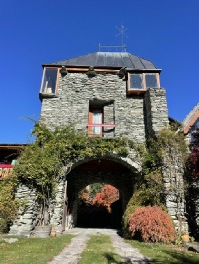 'Whakatipua', Arrow Junction: the schist tower and its arched carriageway, seen from the garden